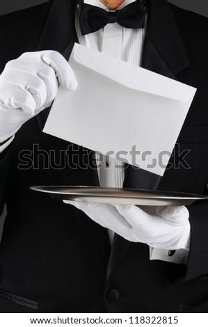 Closeup of a butler wearing a tuxedo holding a silver tray and an envelope. Vertical format, man is unrecognizable. Royalty-Free Stock Photo #118322815