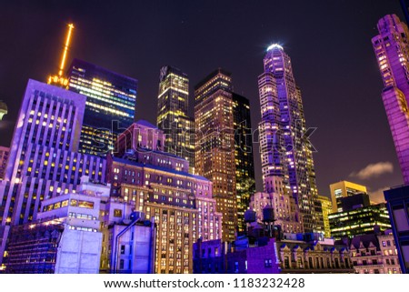 The New York skyline in Manhatten. A purple glow covers the many buildings.