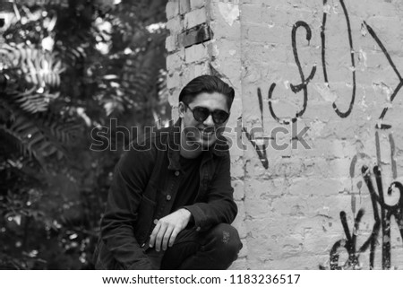 black and white photo, man posing near building