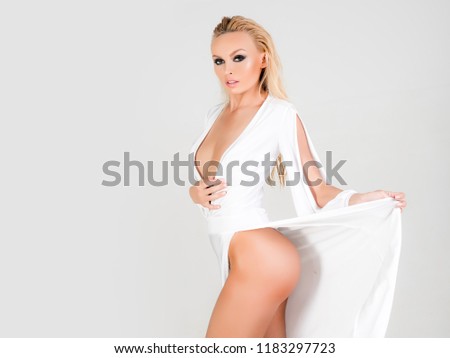 Buttocks plastic surgery. A new body. Buttocks implants. Beautiful Blond Girl In Fashionable Dress Showing An Ass. Plastic surgery, beauty, people and bodycare concept. Cellulite problem concept.