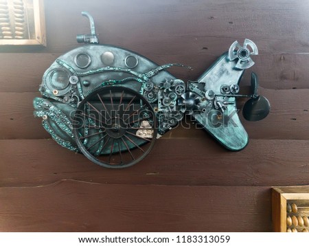 scrap-metal fish made from recycle metal on old wooden wall