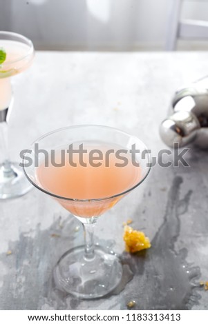 Bellini cocktail with peach and honey , with a spilled beverage on a concrete background over windows, copy space