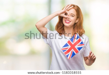 Young beautiful woman holding flag of united kingdom over isolated background with happy face smiling doing ok sign with hand on eye looking through fingers