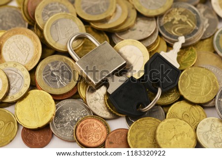 Investment or savings security concept with key and padlock on coins
