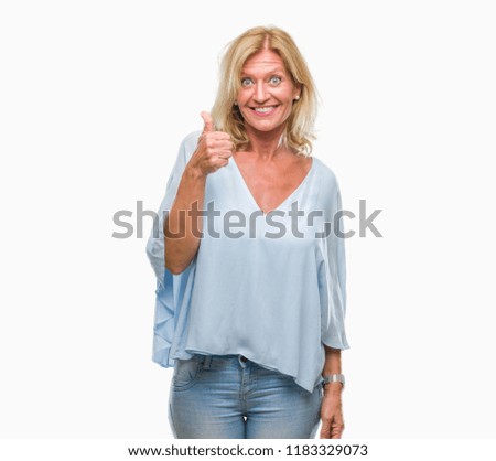Middle age blonde business woman over isolated background doing happy thumbs up gesture with hand. Approving expression looking at the camera with showing success.