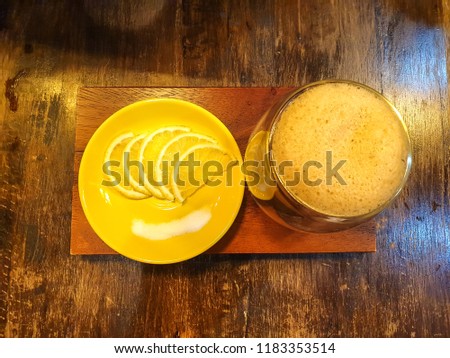 Lemon coffee on the wood table in the cafe.