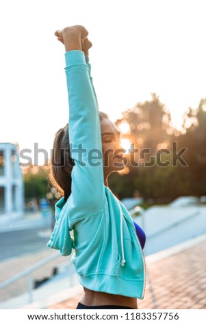 Photo of amazing young sports woman in park outdoors make sport stretching exercises.