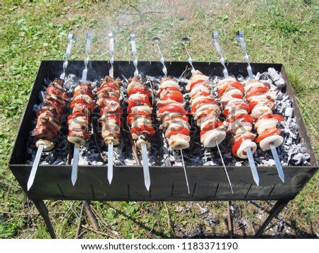 Shish kebab Grilling shish kebab. In the picture there is a roasted of eight skewers, and the hand that overturns Shish kebab.