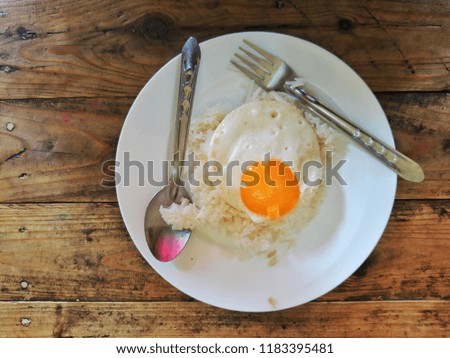 rice with fried egg on round dish, breakfast concept.