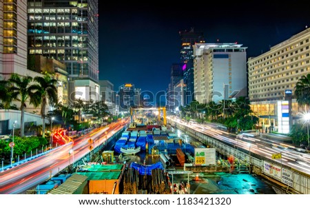 Monorail or mass rapid transit construction at night, in M.H Thamrin Street, Jakarta. Showing beautiful buildings and light trail from busy traffic.  Urban Skyline, Building Exterior, Capital Cities