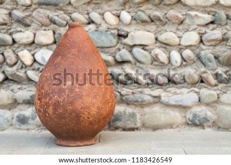 Old Kvevri on stone background, Georgian earthenware vessels for wine. Focus on the kvevri. Royalty-Free Stock Photo #1183426549