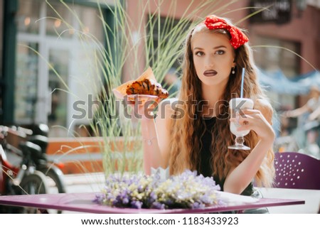 Young woman having a french breakfast with coffee and croissant sitting oudoors at the cafe terrace. Good morning. Cappuccino. Coffee. Croissant. Terrace.