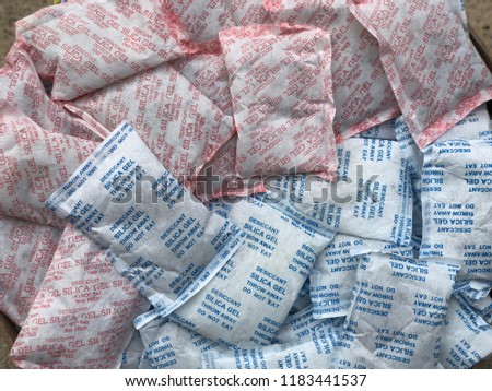 Pile of Desiccant silica gel, with dark tone, used for moisture protection in the food industry, on packaging has the label clearly labeled "Desiccant, Silica gel, Throw Away, Do not eat". Royalty-Free Stock Photo #1183441537