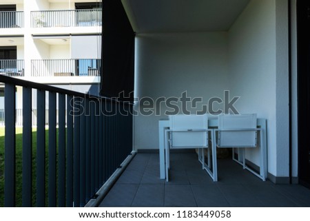 Exterior modern white condominium building with lots of lawn, nobody inside