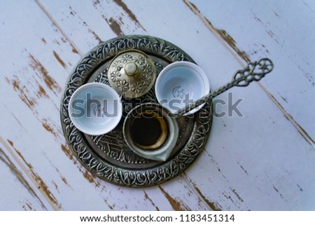 A tray with two traditional empty coffee cups, Turkish coffee kettle and Turkish delight cup together.
