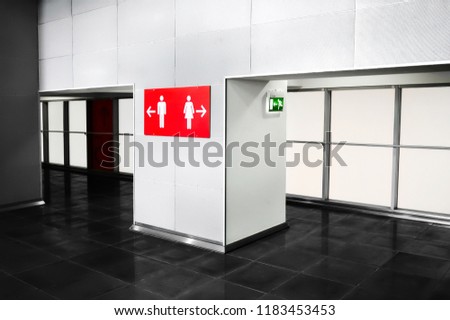 Public place bathroom services indication sign. Toilette navigation in big modern mall or business center. Grey tones interior design with bright red indicators.