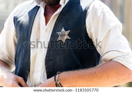 A man with the star shaped sheriff badge in his vest. Wild west justice officer and lawman Royalty-Free Stock Photo #1183505770