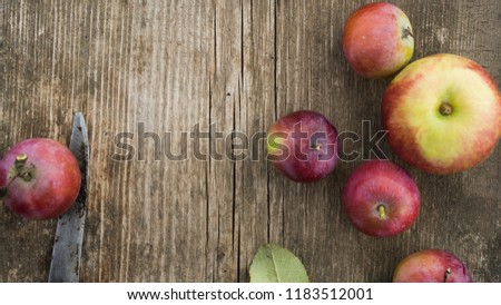 Fresh red apples with green leaves on wooden table.