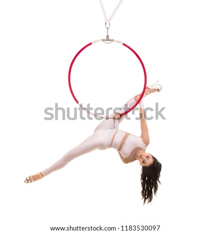 A young girl performs the acrobatic elements in the air ring. Studio shooting performances on a white background.
