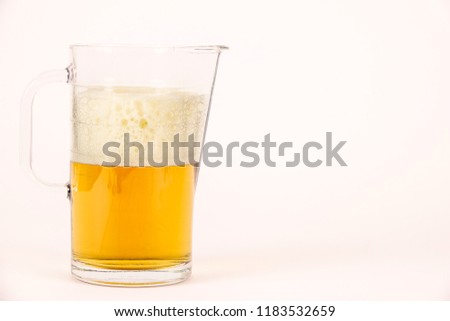Pitcher of beer with foam on white background. Blank empty copy space for text.