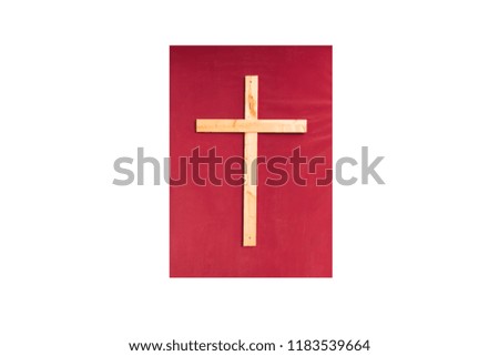 wooden cross on red velvet fabric isolate on white background.