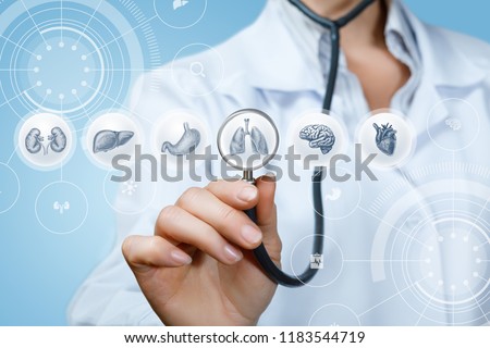 Doctor listens to the internal organs on a blue background. Royalty-Free Stock Photo #1183544719