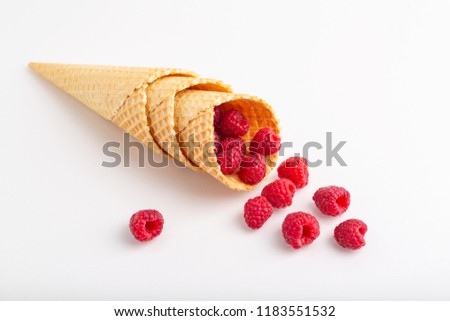 Ice cream or delicious dessert made from fresh raspberry berries on white background. Raspberry in a waffle cone. Summer, freshness, and the concept of the sweet menu.