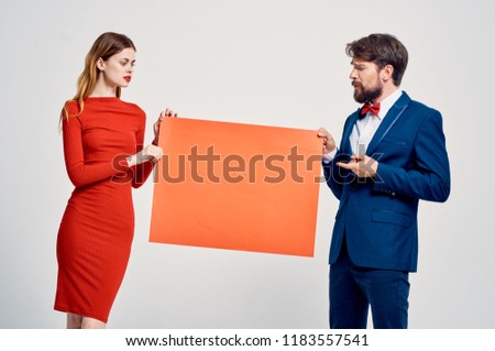 man woman holding a orange layout                             