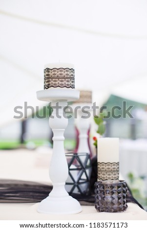 Wedding set up for table decoration. Wedding ceremony and decorations in black and white colors. Gothic style accents. Candles wrapped in black lace. vertical template stories