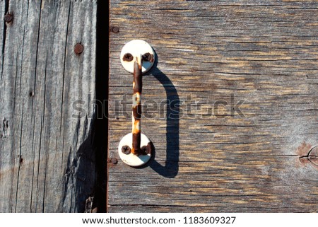 Close-up plywood door with a rusty door handle