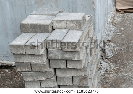 Stone bricks piled near a wall at a construction site