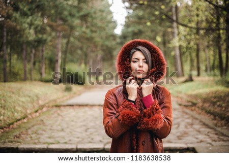 elegant woman covering herself with coat on a cold autumn day