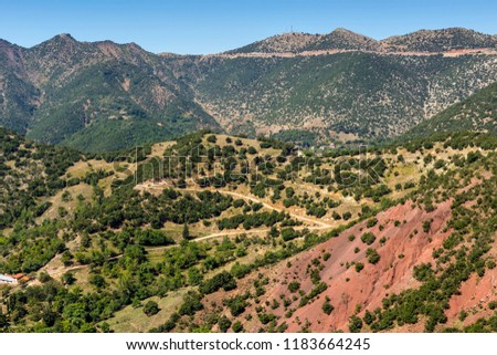 Mountain village from a height in the valley near the mountains on a sunny summer day (Achaea, Greece, Peloponnese).