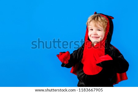 Boy in costume celebrating Halloween. Trick or treating on Halloween party. Kid in fancy costume. Happy Halloween Weekends. Halloween holiday concept. Child in devil costume in red&black with horns.