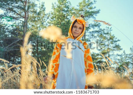 A young girl in a giraffe costume walking in the city Park. emotional portrait of a student. A woman walks in the summer forest on a Sunny day in the fresh air.
