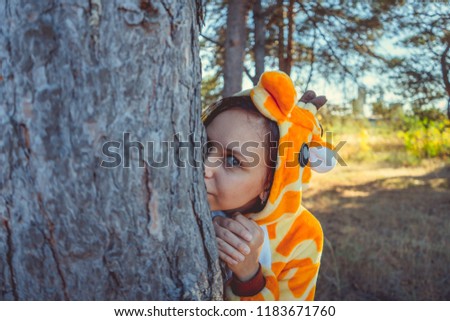 A young girl in a giraffe costume walking in the city Park. emotional portrait of a student. A woman walks in the summer forest on a Sunny day in the fresh air.
