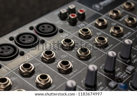 rows of silver gold  audio input connectors, on a professional audio mixing console/ desk