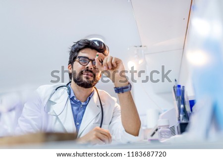 Attractive male scientist holding a  pill. Male doctor holding a pill. Pharmacist holding a pill. Hand of a hospital medical expert shows the pill to be taken to his patient. 