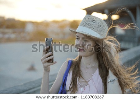 Happy Hopeful Woman Looking at the Sunset by the ocean. Happy smiling girl enjoying the beach and looking at camera.Woman at the beach wearing sunhat