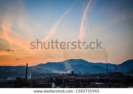 iron industry near city , blue and orange sky