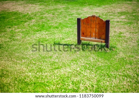 Blank Weathered Wooden Sign In The green Lawn.with copyspace