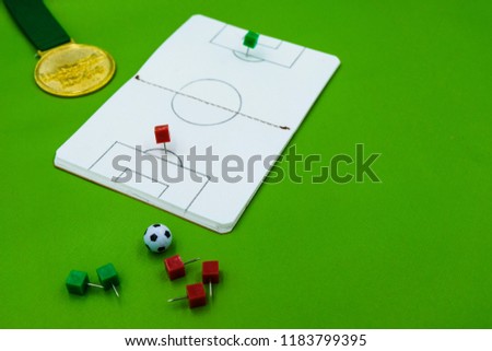 a notebook with soccer pitch pattern representing strategy on green background
