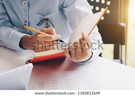 Close-up of female or Secretary hands making notes during discussion of business documents at meeting.Note idea. Business finances and Secretary concept.