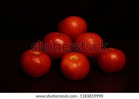 Bunch of red fresh tomatoes are on isolated black background