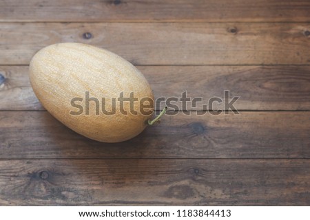 Huge yellow melon on a floor of a wooden terrace