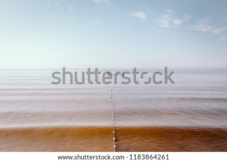 Minimalist seascape with fishing nets in the water.