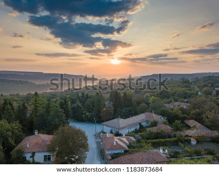 Aerial shot of a small mountain village in Bulgaria - typical rural scenery, beautiful sunrise
