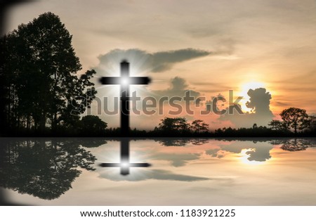 The orange sky has sun, there is a cross that shines and shines on the water.