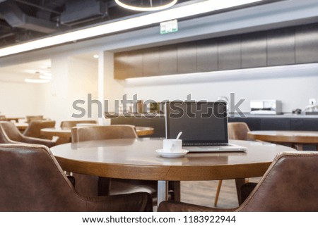 Laptop drinking coffee on the round table, modern style office interior