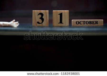 Wood block and little hand on black background. 31 October. Holiday season. Halloween party. Can be use for advertising, banner, brochure, web. Free space for text.
